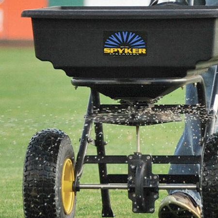 Broadcast spreader applying lawn fertilizer