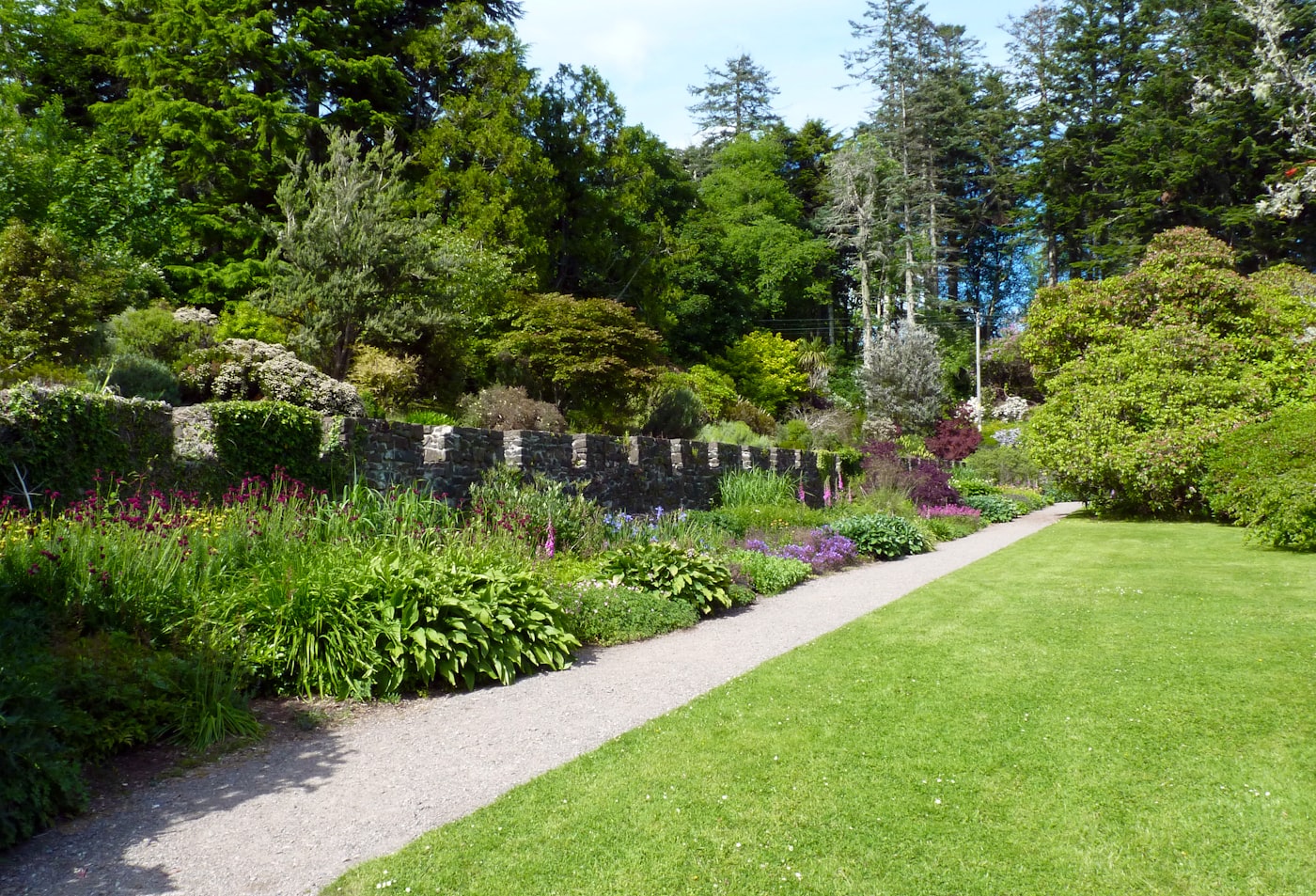 A landscaped garden with stone wall and lawn
