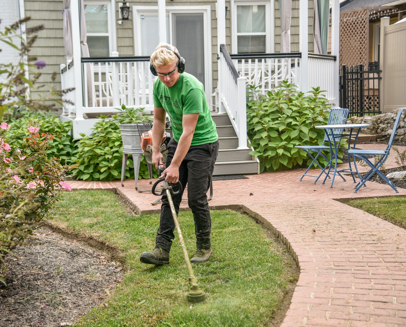 A Cypress Landscaping worker edging a residential lawn